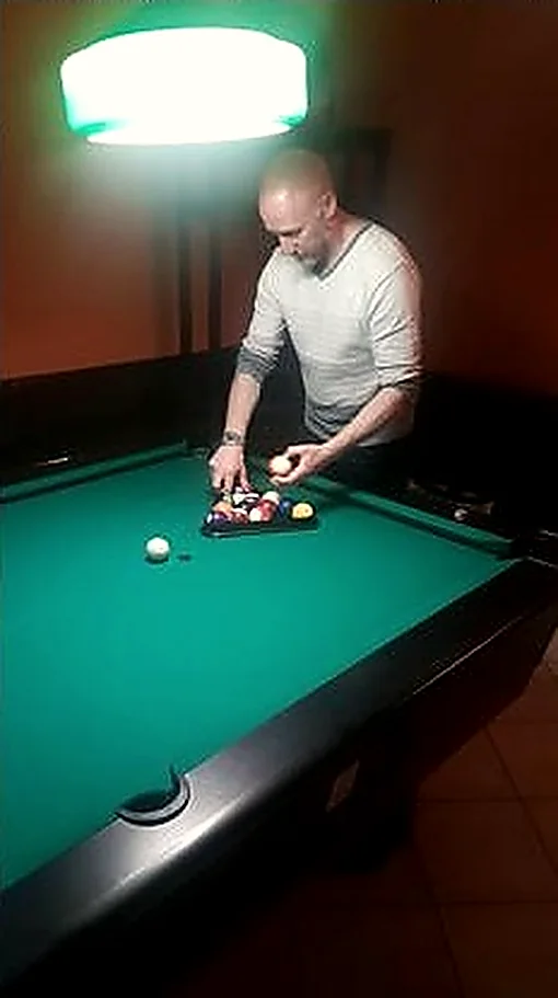 Una partita a biliardo di sera, sotto la lampada verde.